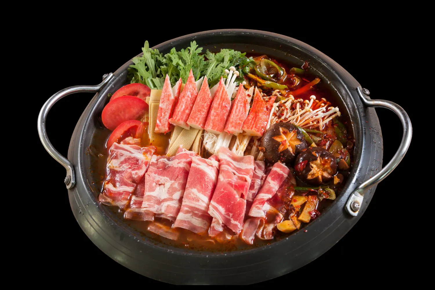 Spicy red broth hot pot filled with beef rolls, crab sticks, mushrooms and fresh greens at Feast Utopia Clackamas, an Asian Fusion Restaurant in Clackamas